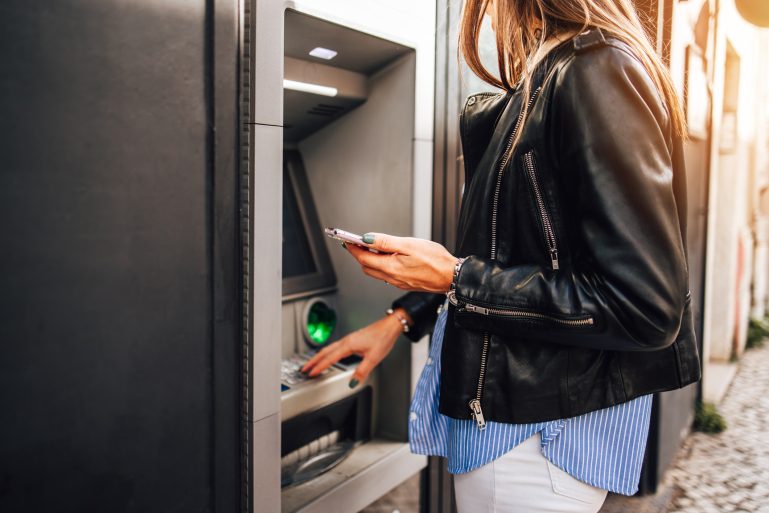 Une femme devant le distributeur d'une banque
