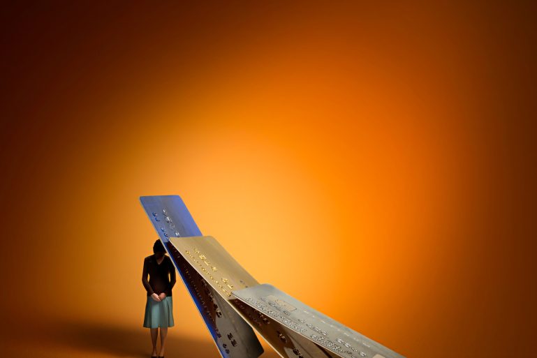 Une figurine accablée par des cartes de crédit