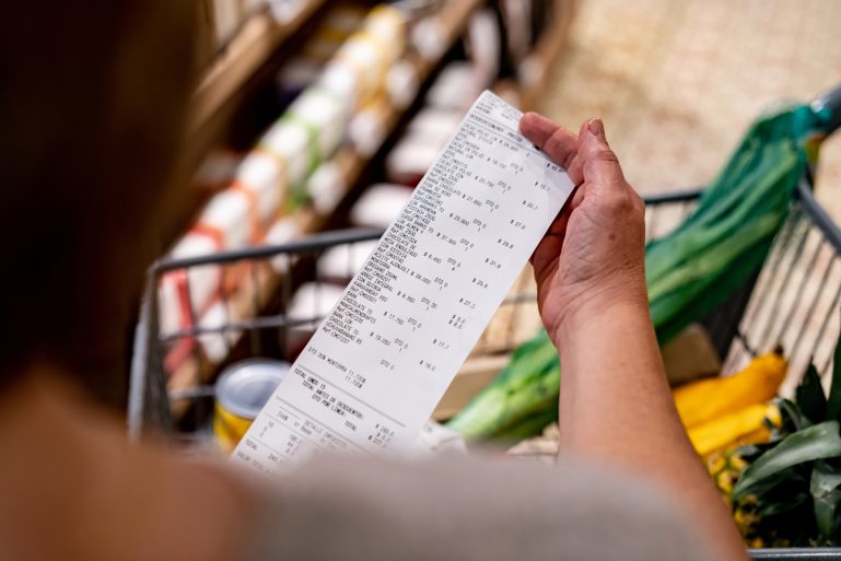 une cliente de supermarché vérifie son ticket de caisse