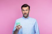 Un homme avec un smartphone affiche sa surprise