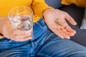 Une personne sur le point d'avaler des compléments alimentaires