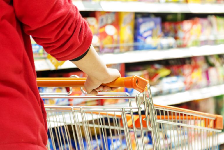 Un homme pousse un chariot dans un supermarché