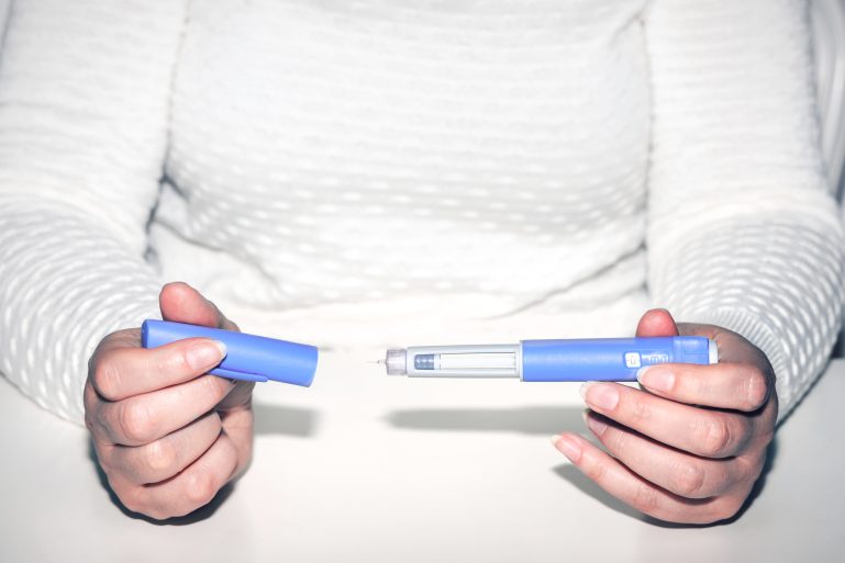 Une femme tenant un stylo d’injection pour diabétique