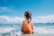 Une petite fille assise en bord de mer