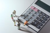 Des figurines en discussion autour d’une calculatrice