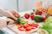 Une femme en train de découper des légumes pour une salade