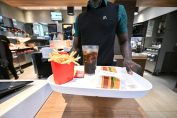 Un équipier MacDonald's sert un menu sur un plateau