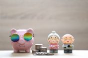 Un cochon tirelire à côté de deux figurines de retraités