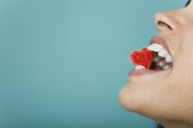 Une femme tient un cœur en bonbon entre ses dents