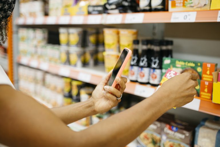 Une consommatrice scanne un produit dans un magasin
