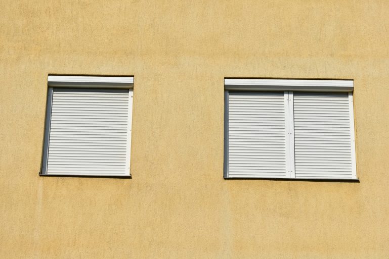 Une façade avec des volets roulants fermés