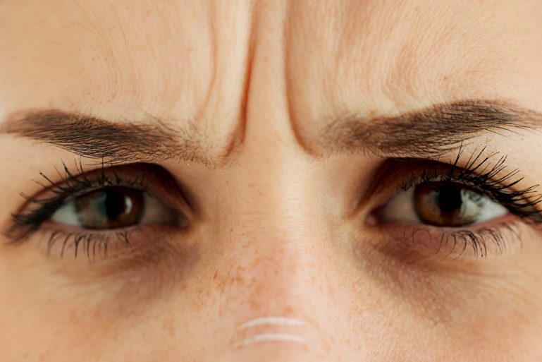 Une femme les yeux froncés