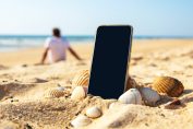 Un smartphone planté dans le sable sur une plage