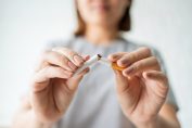 Une femme rompt une cigarette en deux