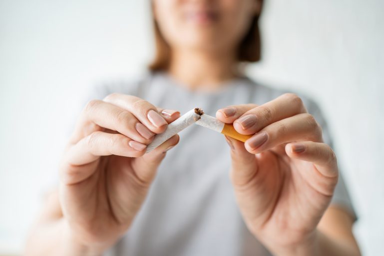 Une femme rompt une cigarette en deux