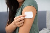 Une femme s'applique un patch d'hormones sur le bras