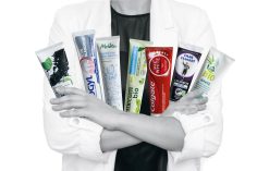 scientifique tenant des tubes de dentifrice dans ses bras