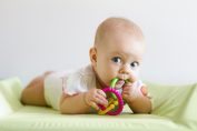 Un bébé portant un jouet à sa bouche