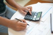 Une personne en train de faire un calcul sur une calculatrice