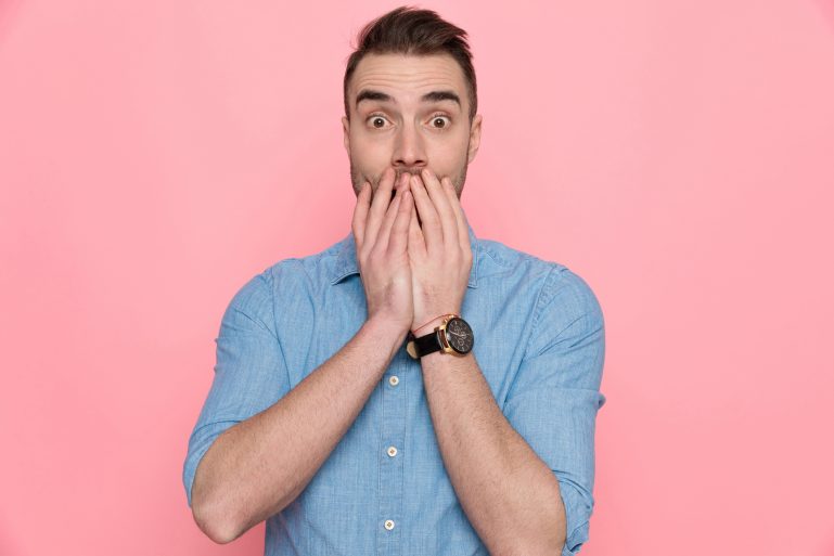 Un homme cache sa bouche avec ses mains