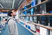 Un homme circonspect devant le rayon TV