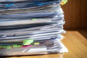 Une pile de papiers figurant les fiches de paie de toute une carrière