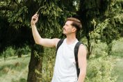 Un homme essayant de capter le réseau mobile dans une forêt