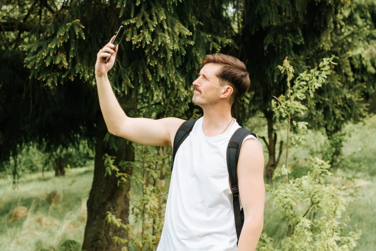 Un homme essayant de capter le réseau mobile dans une forêt