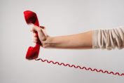 Un téléphone rouge tenu à bout de bras