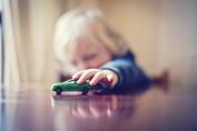 Un enfant joue avec une petite voiture