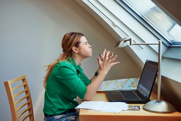 Une jeune femme en colère devant son ordinateur