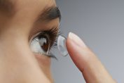 Une femme met sa lentille de contact