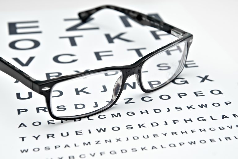 Des lunettes posées sur un test de vision