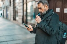 Un homme en train de vapoter dans la rue