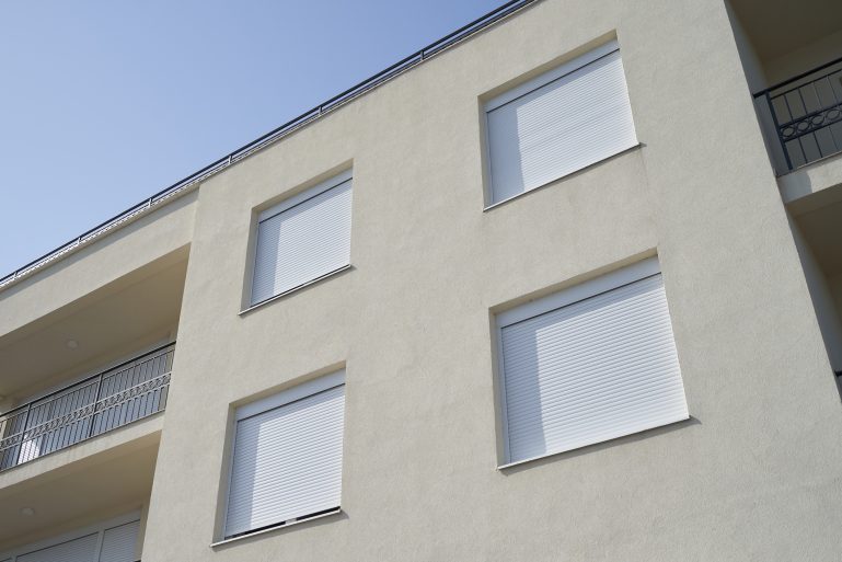 Un immeuble dont tous les volets roulants sont fermés