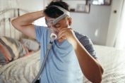 Un homme s'équipe d'un appareil pour l'apnée du sommeil
