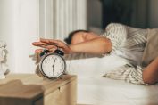 Femme en train d’éteindre son réveil le matin