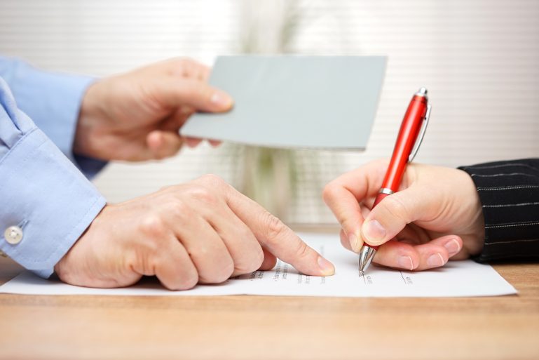 Une personne sur le point de signer un document