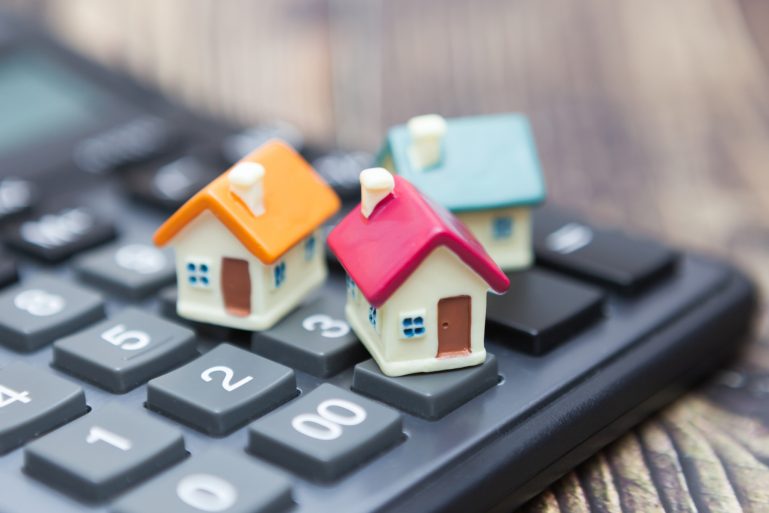 De petites maisons posées sur une calculatrice