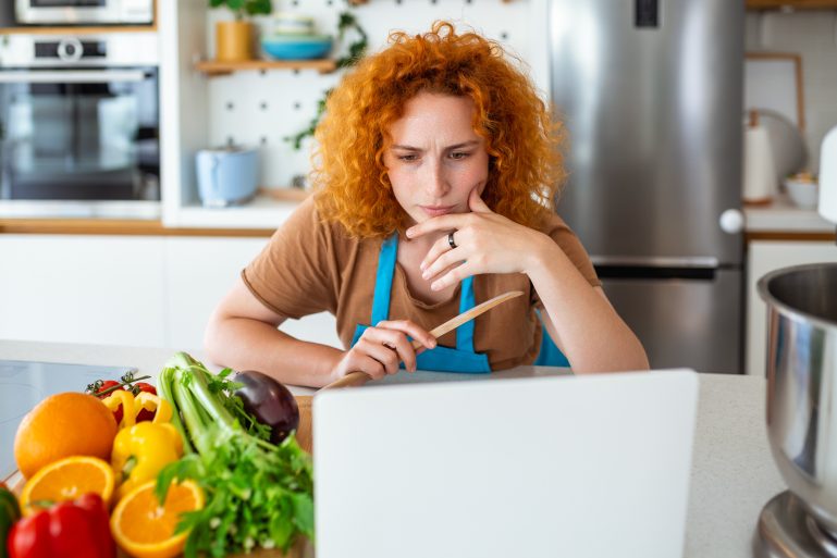 Une femme cuisine avec des légumes