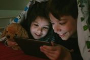 Des enfants regardent un écran en cachette