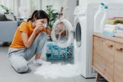 Une femme catastrophée devant son lave-linge en panne