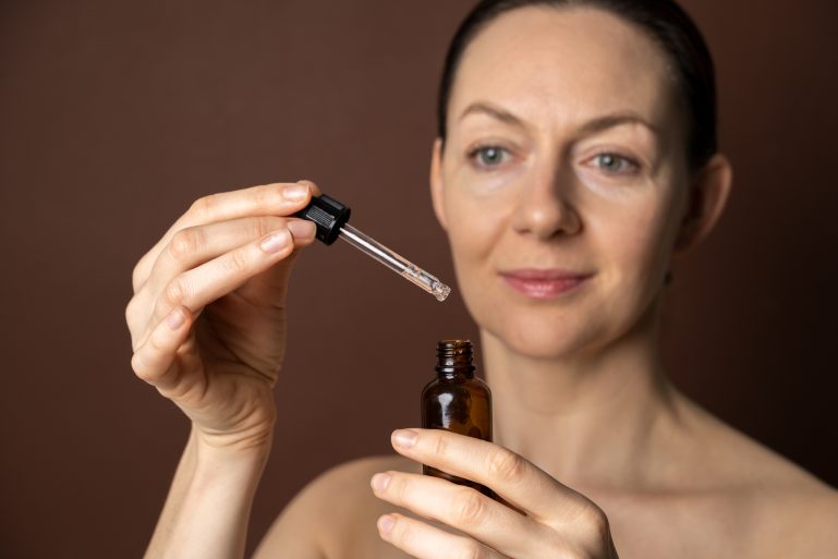 Une femme s'applique un sérum lissant