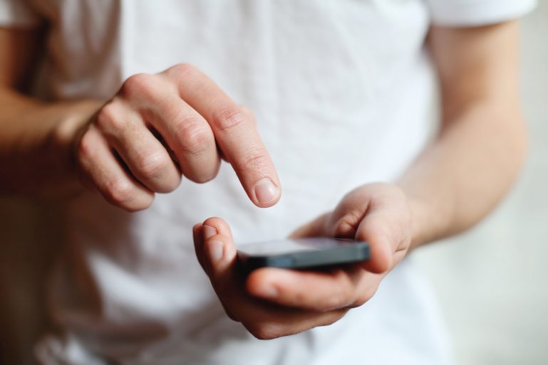 Un gomme clique sur l'écran de son smartphone