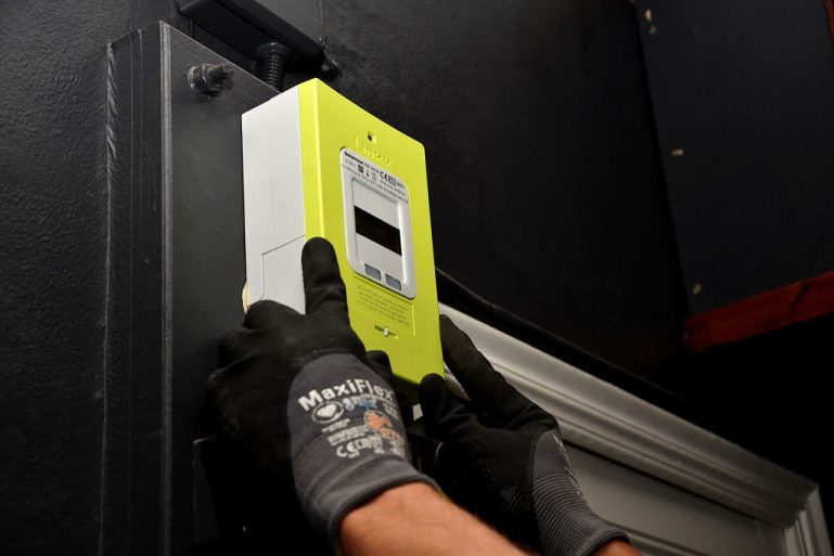 Un technicien pose un compteur Linky