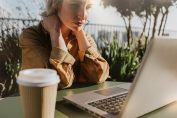 Une femme regarde pensivement l'écran de son ordinateur
