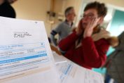 Une femme se tient la tête entre les mains devant une facture d'électricité