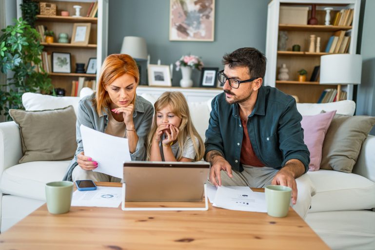 Un couple avec un enfant regarde une feuille