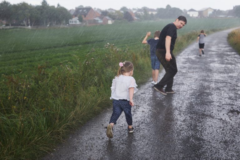 Une famille sous la pluie à la campagne