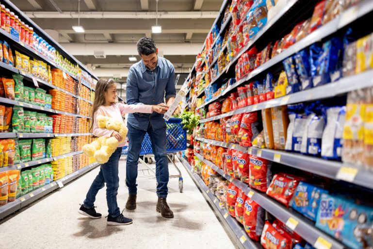 Une petite fille fait les courses avec son papa dans un magasin